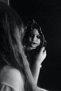 a-little-girl-looking-at-the-mirror-to-see-a-spooky-reflection.jpg